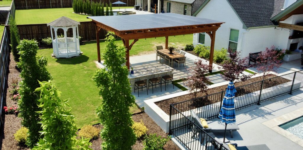 Custom cedar pergola with outdoor kitchen and dining area built for a Tulsa homeowner by Modern Woodscapes